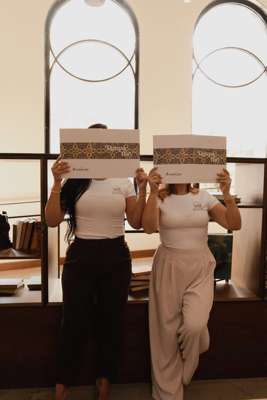 The team holding Solara market guides under arched windows